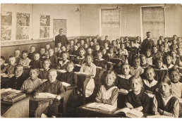 Old school room with crowd of students seated.