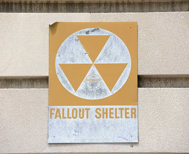 Sign on a nuclear fallout shelter with the atomic fallout design.