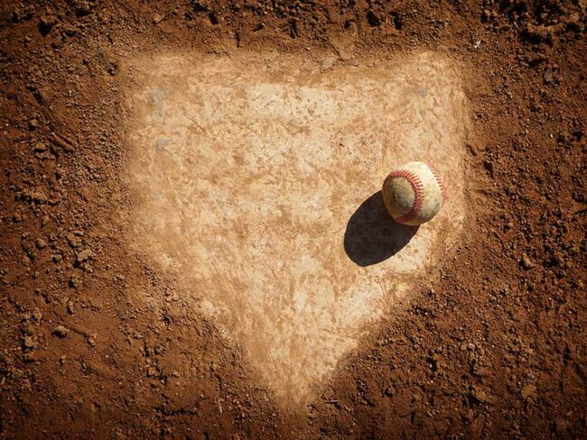 Old baseball on dusty home plate