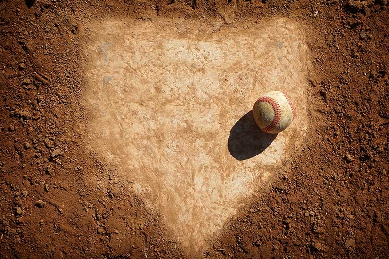 Old baseball on dusty home plate