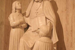 Sculpture of Saint Rose Philippine Duchesne with two children at her feet.