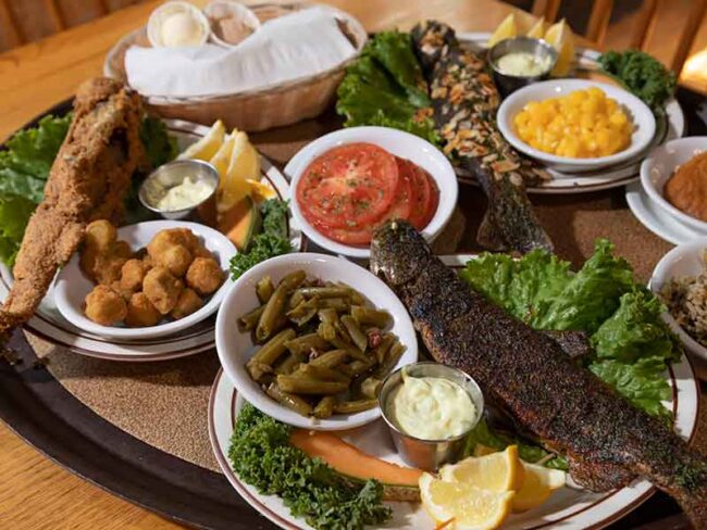 Fried fish platter with green beans, okra, macaroni and cheese with tomato and lemon garnishes at the Dining Lodge at Bennet Spring State Park