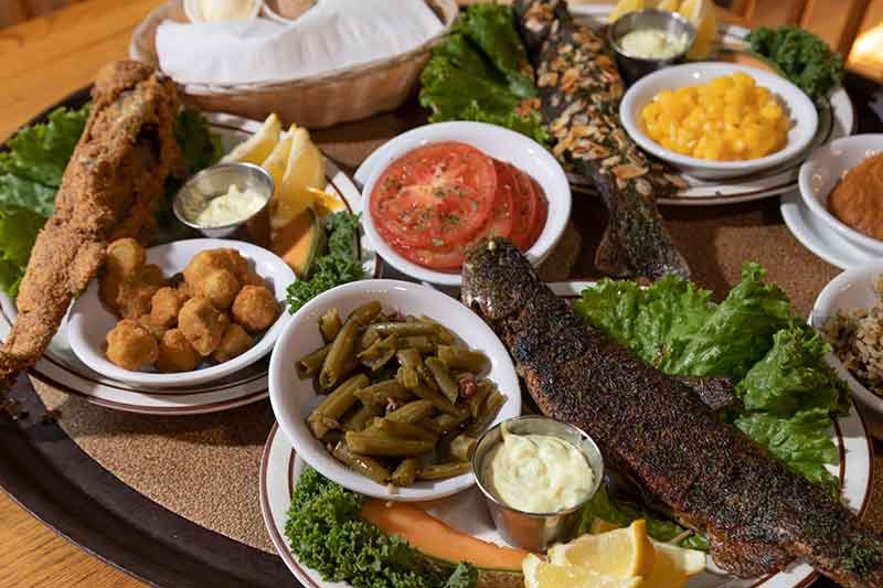 Fried fish platter with green beans, okra, macaroni and cheese with tomato and lemon garnishes at the Dining Lodge at Bennet Spring State Park