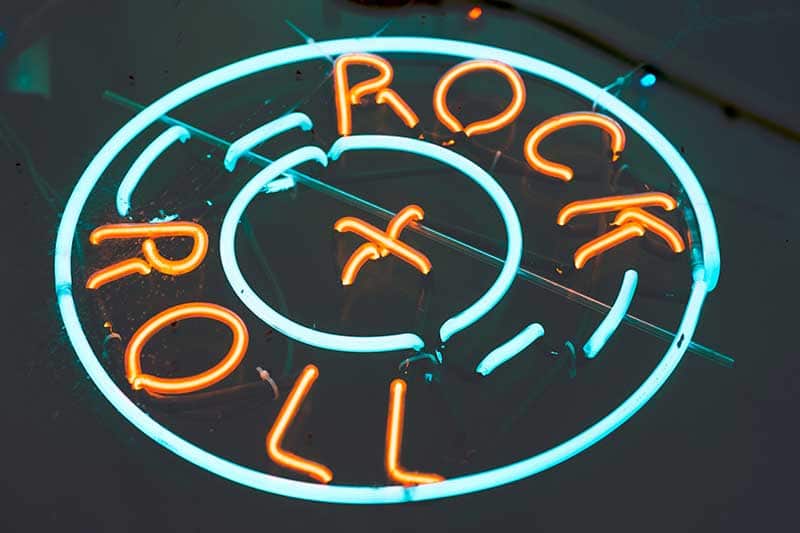 A neon sign with the words Rock and Rock, illustrating a Missouri History Today entry about the first class of inductees into the Rock and Roll Hall of Fame.