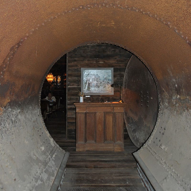 An old molasses tanker salvaged from the original mill leads to the check-in desk and Howard Garrison's painting "A View From My Prison Cell in Ava." 