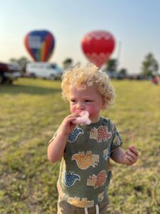 a blond toddler eats some cotton candy