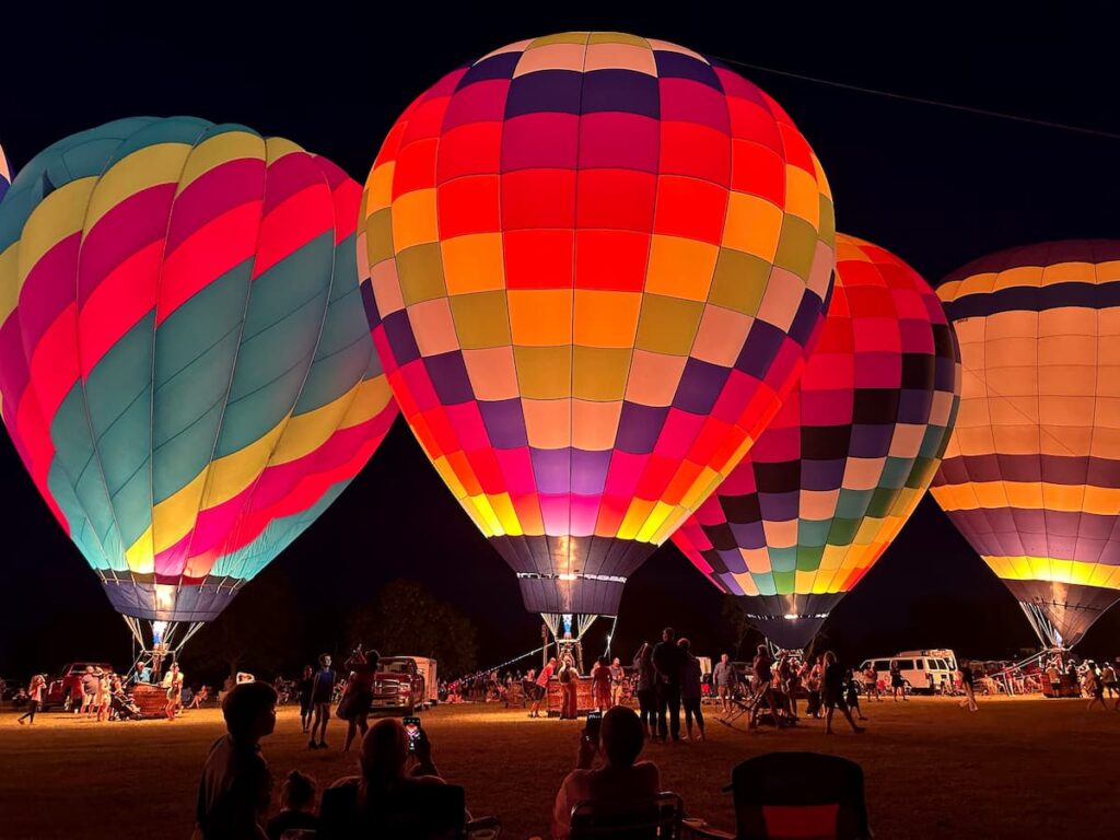 hot air balloons illuminated at night